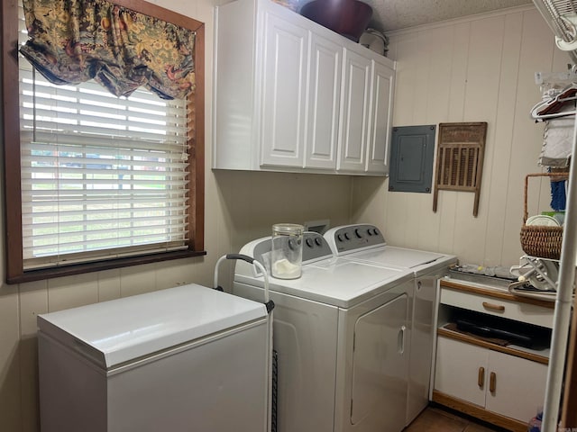 laundry room with washing machine and dryer, cabinets, and electric panel