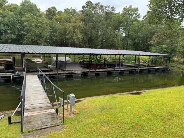 view of dock featuring a water view and a lawn