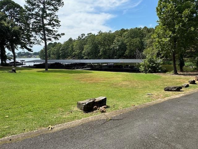 view of property's community featuring a lawn and a water view