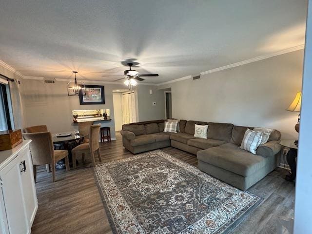 living room featuring crown molding, dark hardwood / wood-style floors, and ceiling fan with notable chandelier