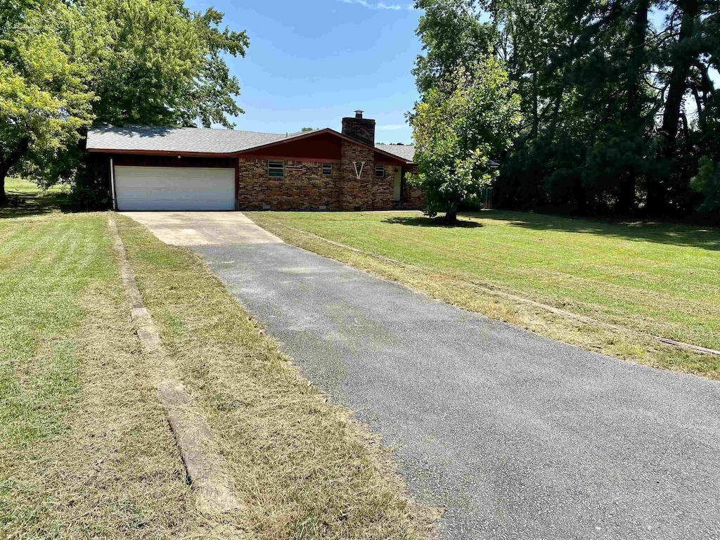 view of front of property featuring a garage and a front lawn