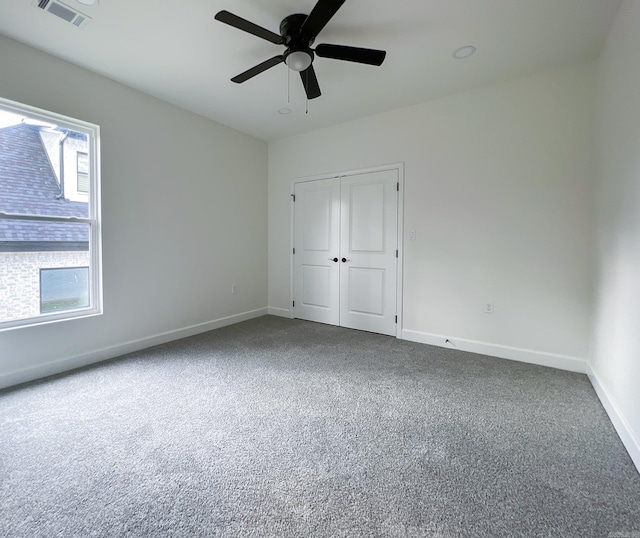 unfurnished bedroom with ceiling fan, carpet floors, and a closet