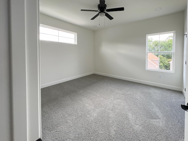 carpeted spare room featuring ceiling fan