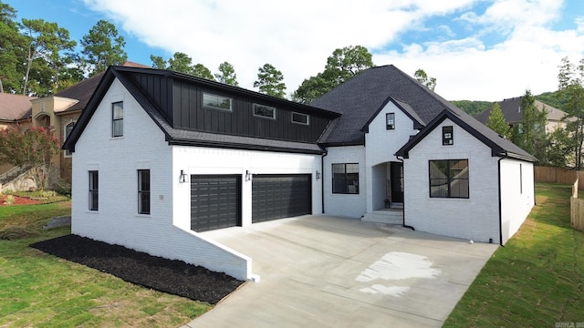 modern inspired farmhouse featuring a garage and a front lawn