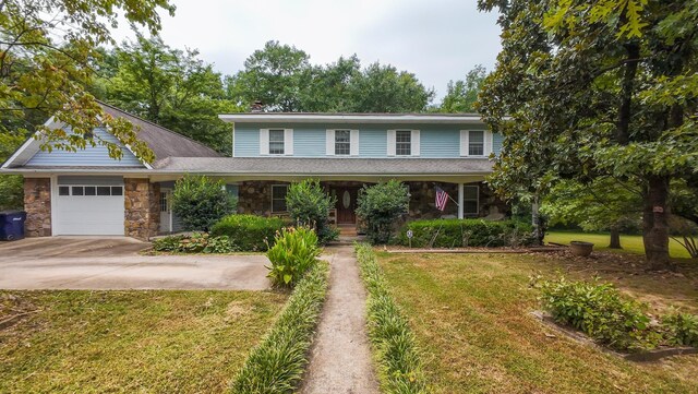 view of front property featuring a garage, a front yard, and a porch