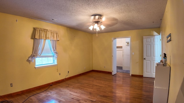 empty room featuring ceiling fan, hardwood / wood-style flooring, and a textured ceiling