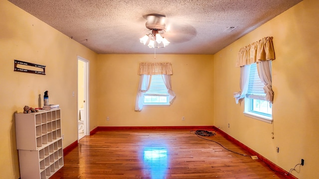 empty room featuring hardwood / wood-style floors, a textured ceiling, a healthy amount of sunlight, and ceiling fan