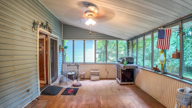 unfurnished sunroom featuring radiator heating unit, vaulted ceiling, a wealth of natural light, and ceiling fan