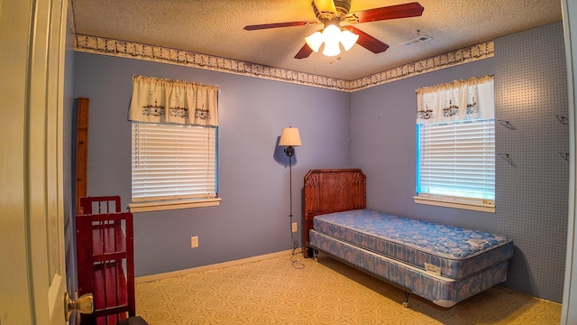 bedroom featuring ceiling fan and a textured ceiling