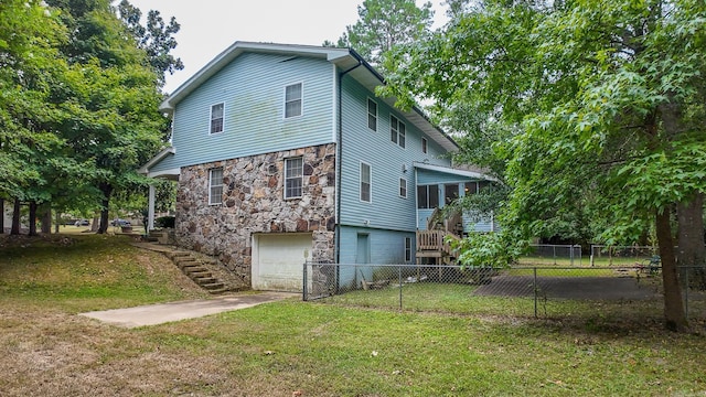 back of house featuring a garage and a lawn