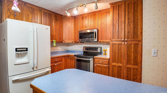 kitchen with tasteful backsplash, appliances with stainless steel finishes, and a textured ceiling