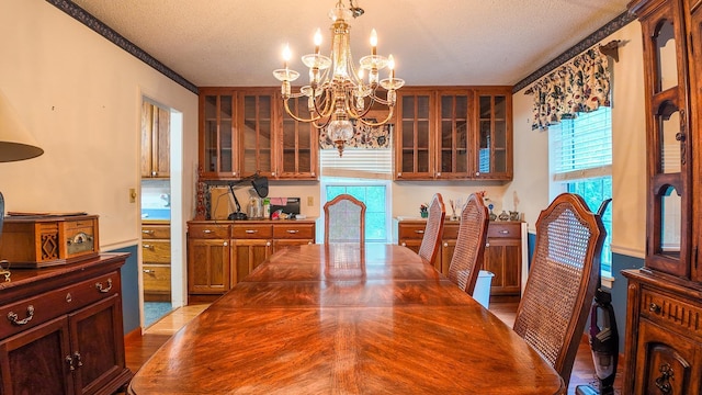 dining area with a wealth of natural light, a notable chandelier, and a textured ceiling