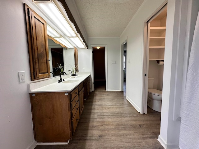 bathroom featuring hardwood / wood-style flooring, a textured ceiling, vanity, and toilet