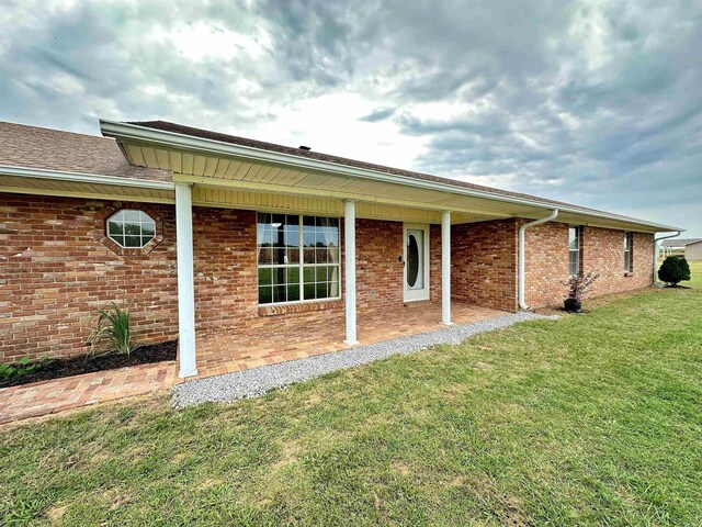 rear view of house featuring a yard