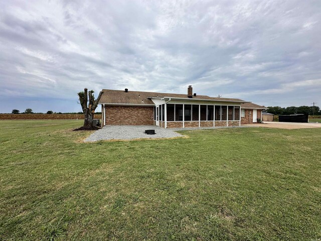 back of house featuring a sunroom and a lawn