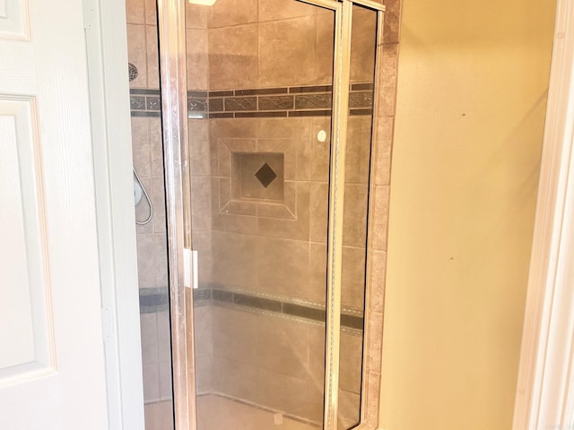 bathroom featuring a shower with door