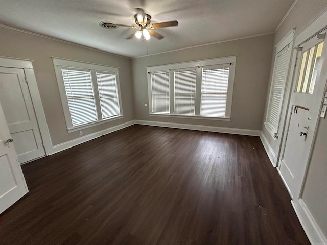 interior space featuring ceiling fan, dark wood-type flooring, and crown molding