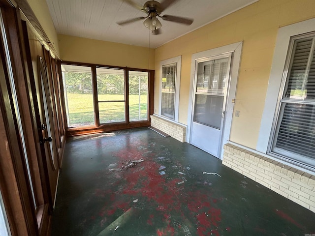 unfurnished sunroom featuring ceiling fan