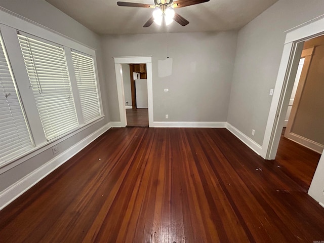 unfurnished room with ceiling fan and dark wood-type flooring