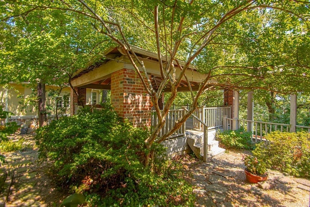 view of home's exterior with brick siding and a wooden deck