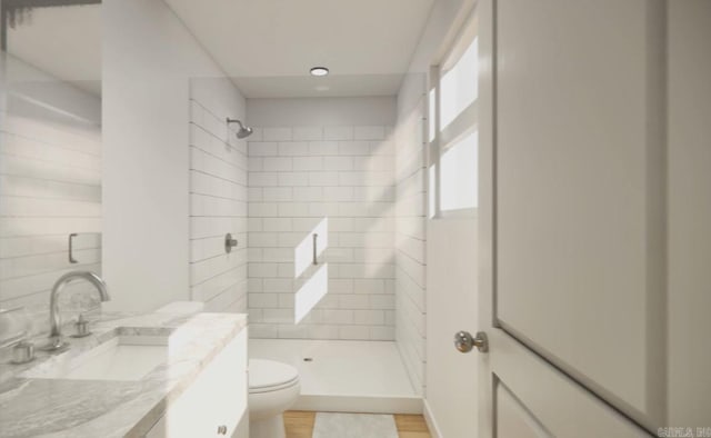 bathroom with toilet, a tile shower, vanity, and hardwood / wood-style floors