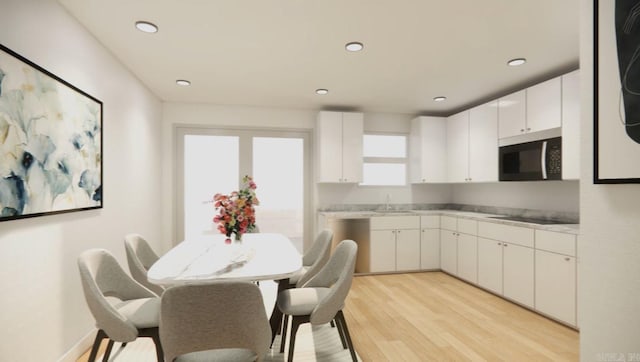 kitchen featuring black electric stovetop, light wood-type flooring, sink, and white cabinetry