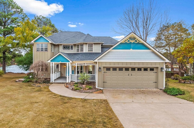 view of front of home with a porch, a garage, and a front yard