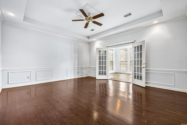 unfurnished room featuring a tray ceiling, french doors, visible vents, and dark wood finished floors