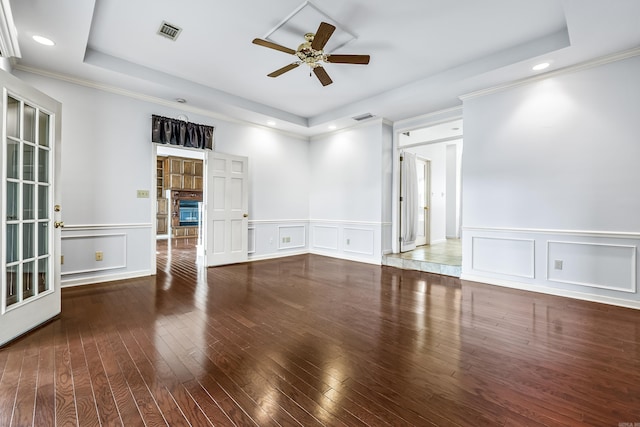 unfurnished room with hardwood / wood-style floors, a tray ceiling, a fireplace, and visible vents