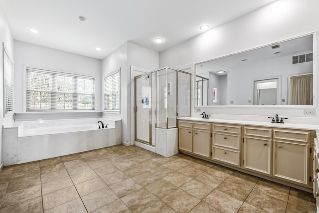 full bathroom featuring a garden tub, double vanity, visible vents, a stall shower, and a sink