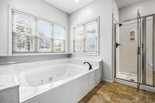 bathroom with a stall shower, tile patterned flooring, and a jetted tub