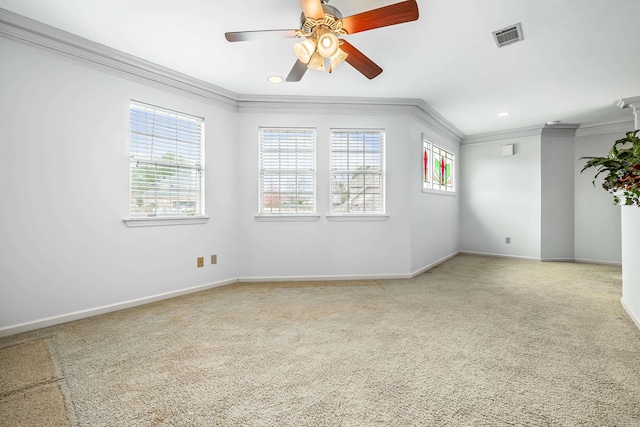 empty room with baseboards, carpet flooring, visible vents, and crown molding