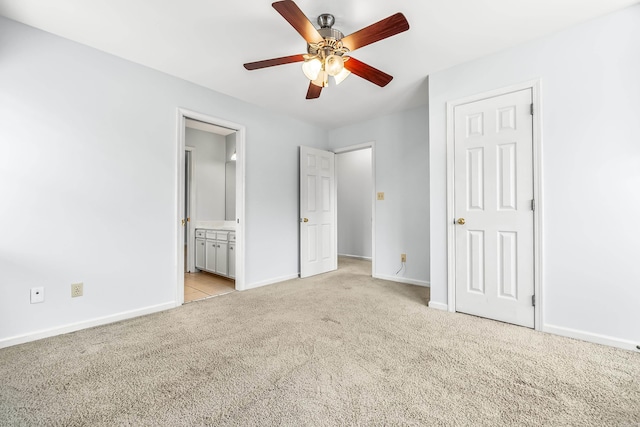 unfurnished bedroom featuring light colored carpet, ceiling fan, ensuite bath, and baseboards