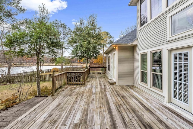 wooden deck with a water view and fence