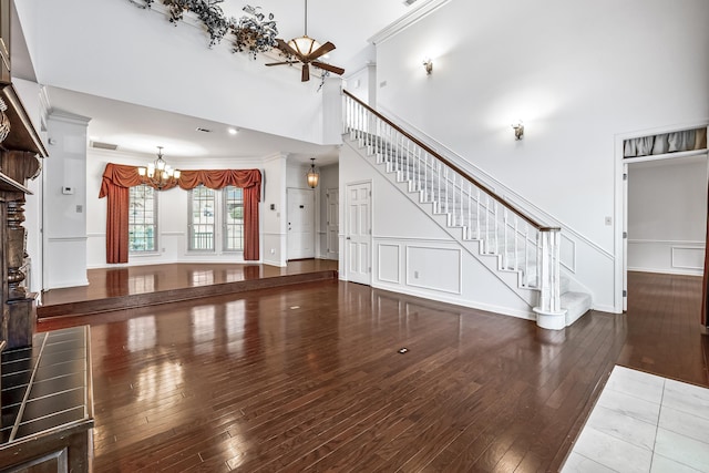 unfurnished living room with stairs, a decorative wall, and dark wood-type flooring