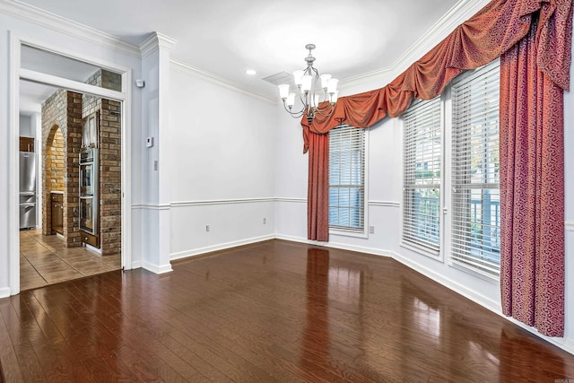 unfurnished room featuring a chandelier, dark wood finished floors, crown molding, and baseboards