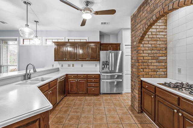 kitchen featuring visible vents, hanging light fixtures, stainless steel appliances, light countertops, and a sink