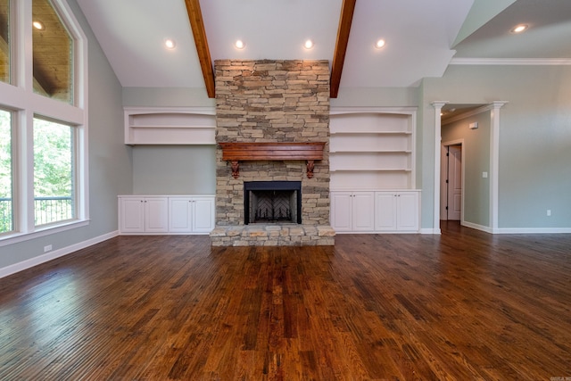 unfurnished living room featuring vaulted ceiling with beams, dark hardwood / wood-style floors, a fireplace, ornamental molding, and built in shelves