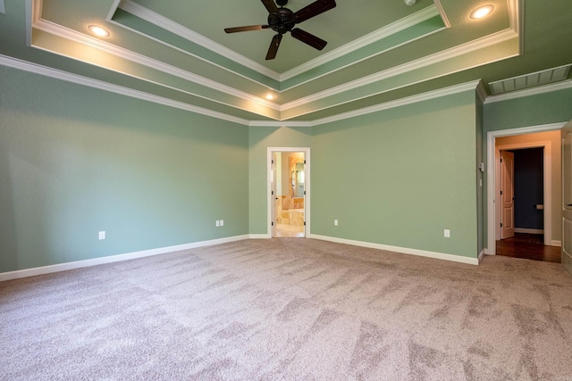 spare room with crown molding, ceiling fan, a raised ceiling, and carpet