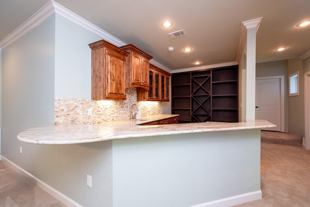 kitchen with sink, ornamental molding, light colored carpet, and kitchen peninsula