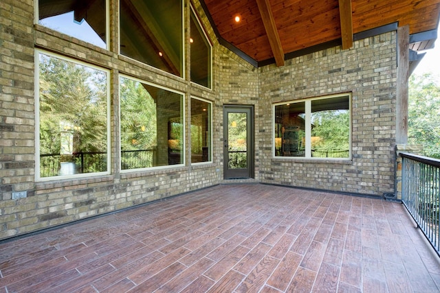 unfurnished sunroom featuring lofted ceiling with beams and wooden ceiling