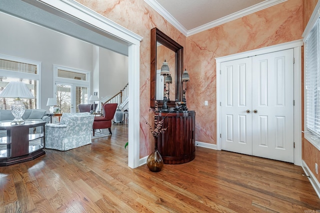 foyer entrance with ornamental molding and hardwood / wood-style flooring