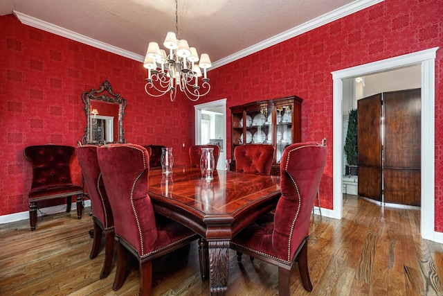 dining space with an inviting chandelier, hardwood / wood-style floors, and crown molding