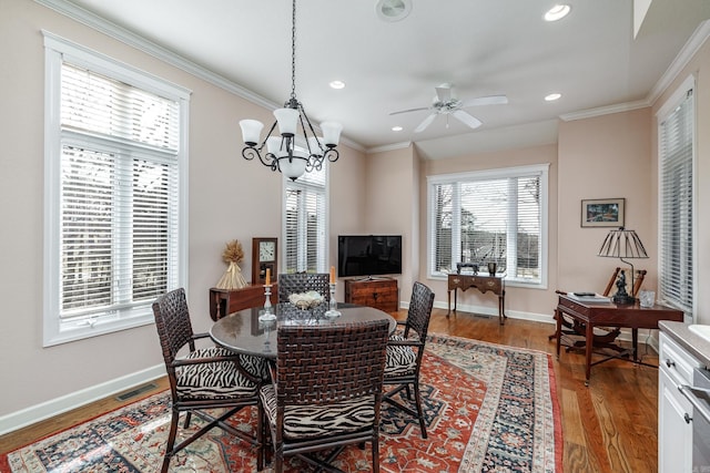 dining room featuring hardwood / wood-style floors, ornamental molding, and ceiling fan with notable chandelier