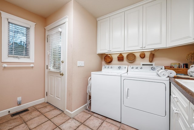 laundry area featuring light tile patterned floors, cabinets, and washer and dryer