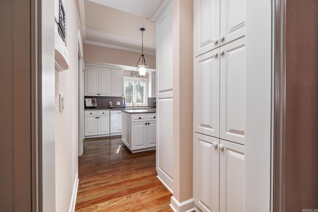 corridor featuring ornamental molding and hardwood / wood-style flooring