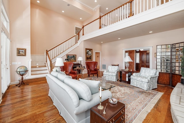 living room with a towering ceiling, hardwood / wood-style flooring, and a wealth of natural light