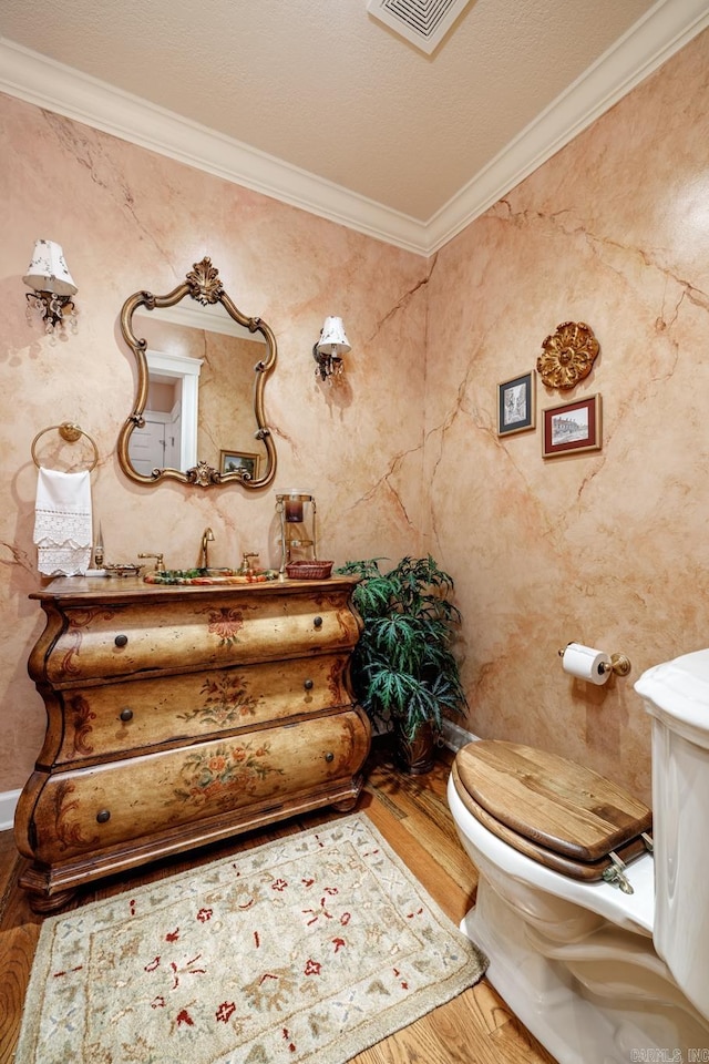 bathroom featuring a textured ceiling, tile walls, toilet, ornamental molding, and wood-type flooring