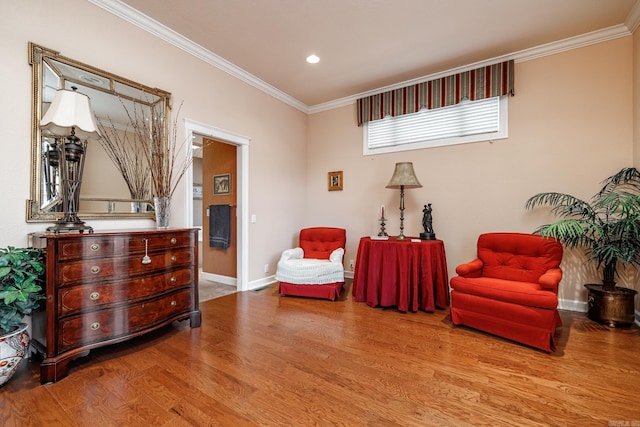 living area featuring crown molding and hardwood / wood-style flooring