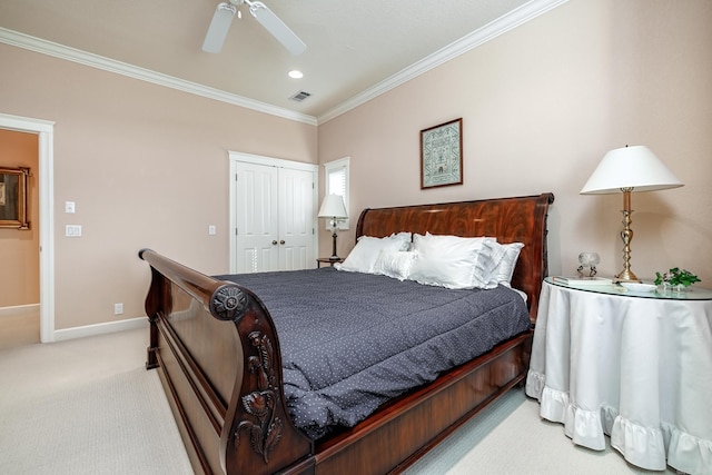 carpeted bedroom with ceiling fan, crown molding, and a closet